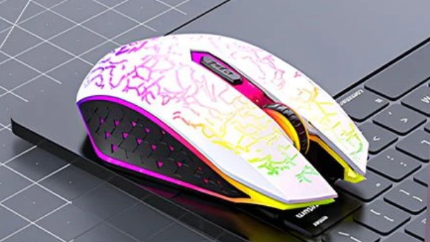 Souris sans fil blanche avec motifs multicolores et éclairage LED latéral sur clavier noir.