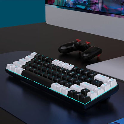 Clavier mécanique ergonomique noir et blanc avec touches blanches en périphérie et rétroéclairage bleu, posé sur un bureau.