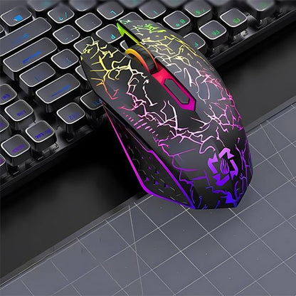 Souris sans fil noire avec motifs lumineux multicolores en zigzag, éclairage RGB, posée sur bureau devant clavier noir.