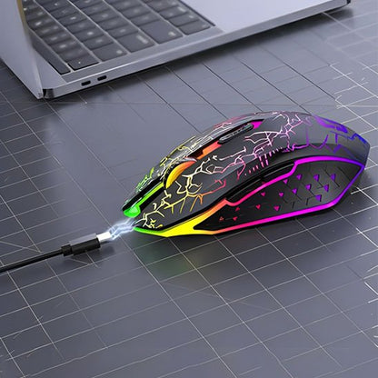 Souris sans fil noire avec motif éclair multicolore lumineux, éclairage RGB, posée sur un bureau gris à côté d’un ordinateur .