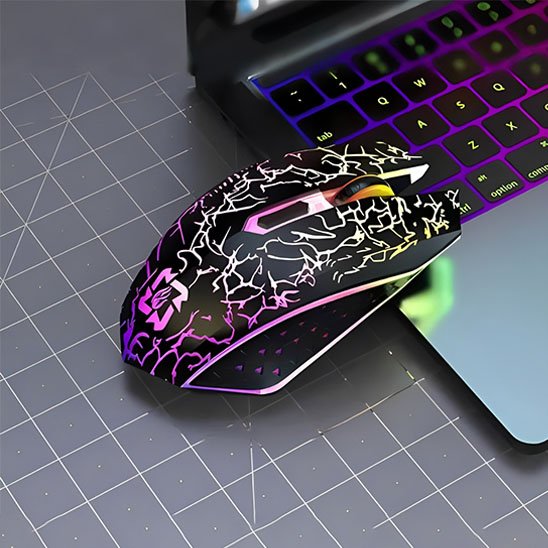 Souris sans fil noire ergonomique avec motifs blancs craquelés, éclairage RVB, posée à côté d’un clavier d’ordinateur.