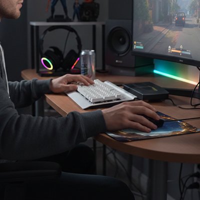 Tapis de souris rectangulaire avec design bleu et motifs jaunes, posé sur un bureau en bois sous une main utilisant une souris.  Clic ton jeu.