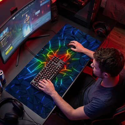 Sous-main bureau grand format avec motif géométrique bleu et éclairs lumineux multicolores, clavier mécanique noir et souris .